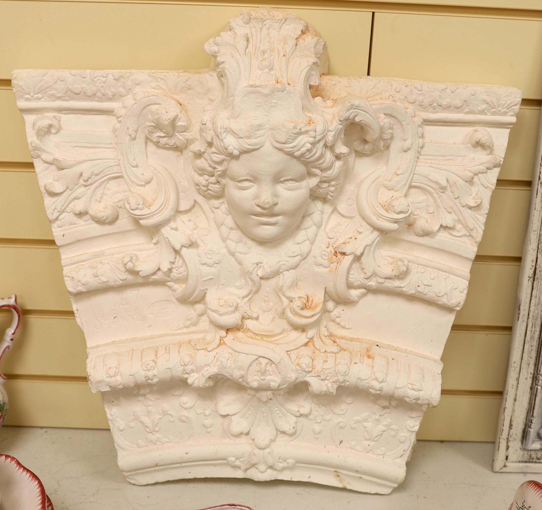 A 20th century plaster cast of a keystone, 50cm wide, 55cm high